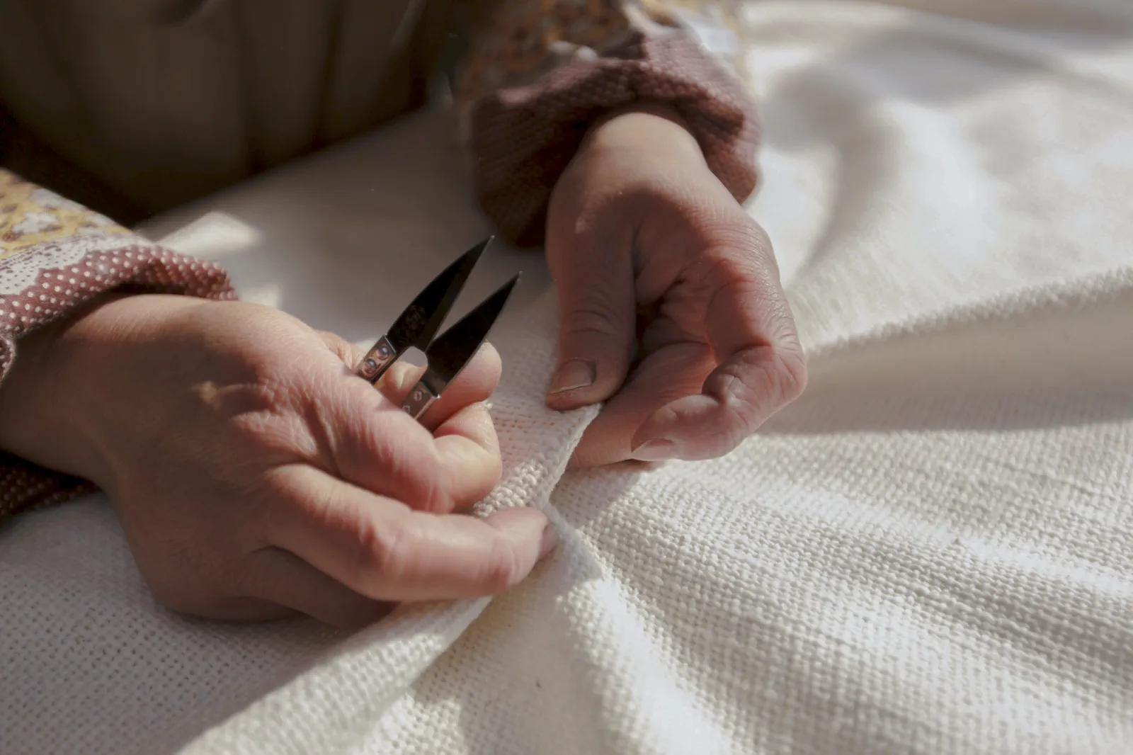 和紡布の補修作業をする職人の手元｜益久染織研究所